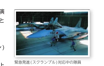 格納庫内で緊急発進（スクランブル）対応を行う隊員と戦闘機の写真