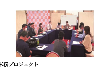 会議室でテーブルを囲んで話し合う人々の様子