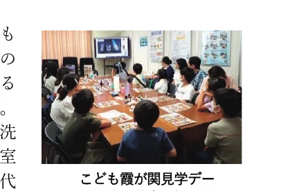 「こども霞が関見学デー」の様子を写した写真。子どもたちがテーブルを囲んで説明を聞いている様子が写っている。