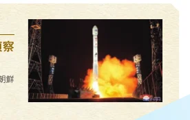 夜間に打ち上げられるロケットと、その周囲に広がるオレンジ色の炎と煙の写真