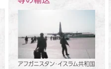 アフガニスタン・イスラム共和国の空港で、飛行機を背景に人々が歩いている様子。