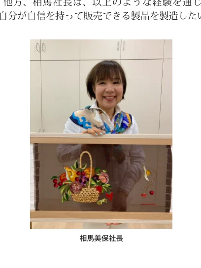刺繍作品を手にする相馬美保社長の写真